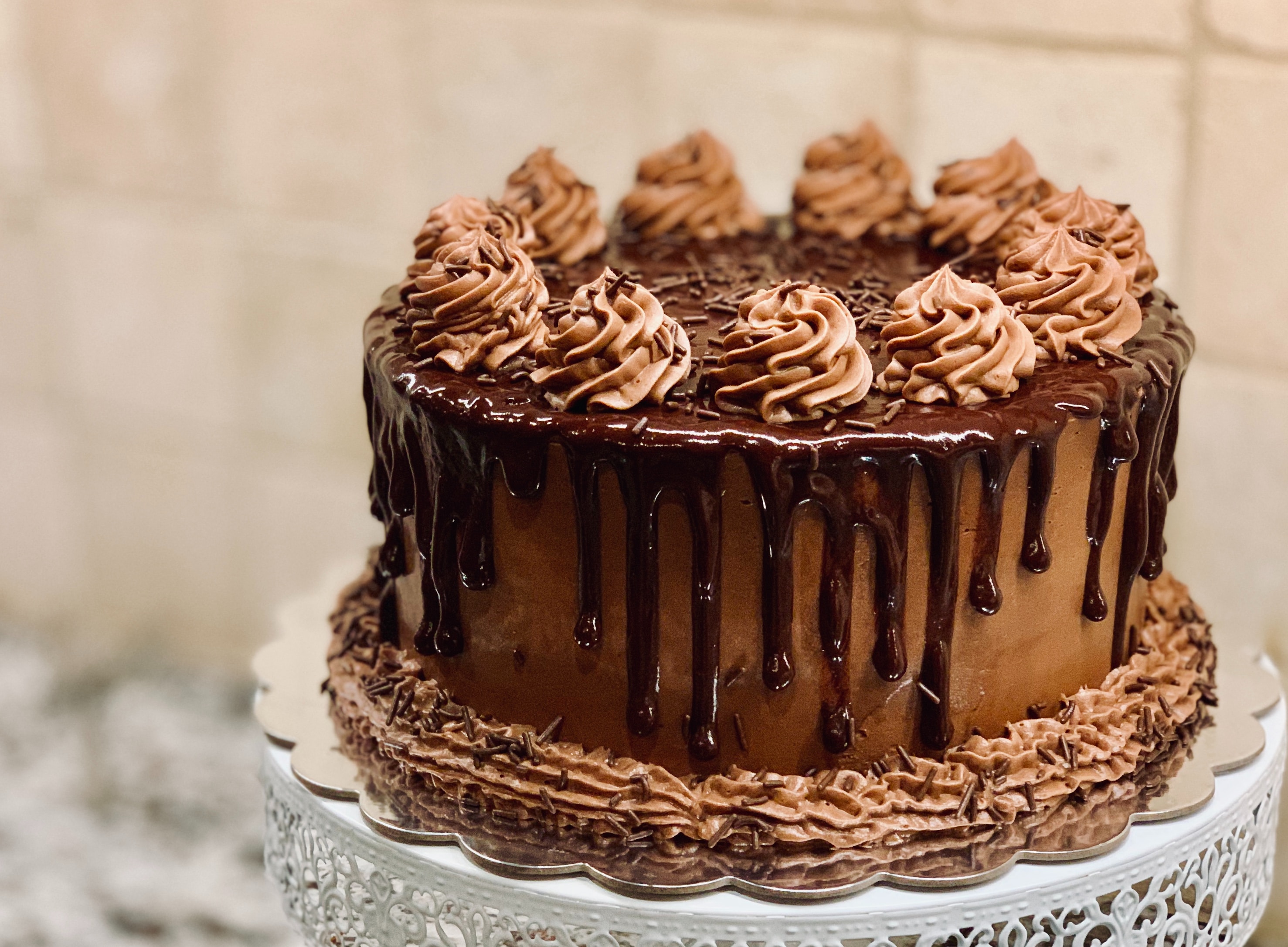 A delicious chocolate cake with rich chocolate drips on top.