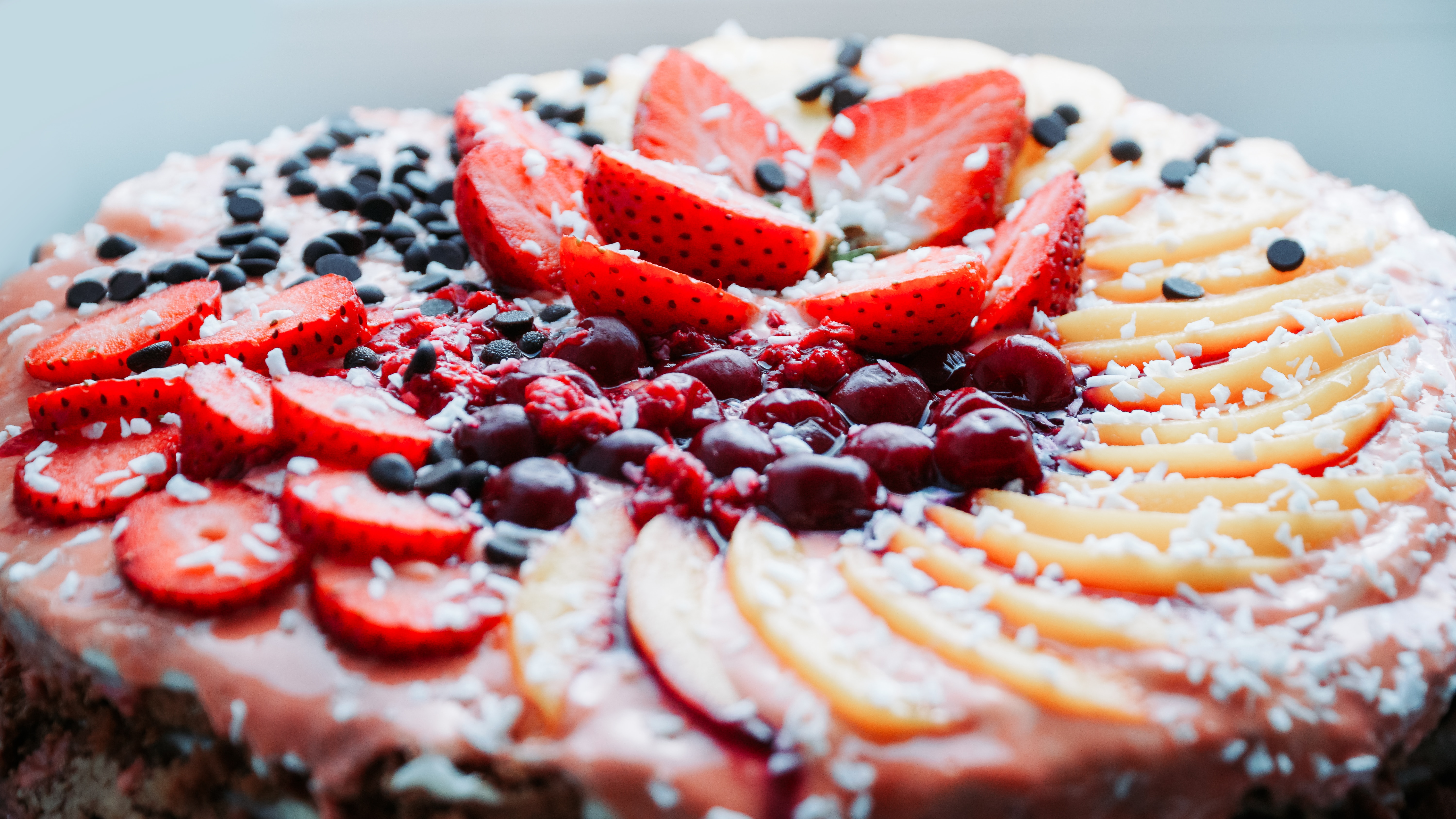 A cake decorated with a variety of fruit toppings